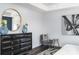 Elegant primary bedroom featuring a dark dresser with gold round mirror and a gray sitting chair at 718 Lithia Inn Rd, Lincolnton, NC 28092
