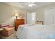 Cozy bedroom features neutral walls, a ceiling fan, a corner chair and a dresser at 7671 Bluff Point Ln, Denver, NC 28037