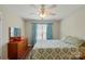 Well-lit bedroom featuring a dresser, window with blinds, and a comfortable bed at 7671 Bluff Point Ln, Denver, NC 28037