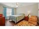 Cozy bedroom with a patterned bedspread, wood floors, matching nightstand and accent chair at 7671 Bluff Point Ln, Denver, NC 28037