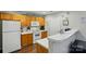 Functional kitchen with white appliances, light wood cabinets and a breakfast bar at 7671 Bluff Point Ln, Denver, NC 28037
