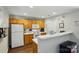 Functional kitchen with white appliances, light wood cabinets and a breakfast bar at 7671 Bluff Point Ln, Denver, NC 28037