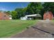 Expansive backyard featuring a carport, barn, and lush green lawn with mature trees at 7869 Cherry Point Dr, Denver, NC 28037