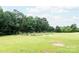 The flat backyard features a garden area and a wooded backdrop at 8340 Brief Rd, Mint Hill, NC 28227