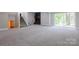 Expansive carpeted basement area featuring a modern fireplace and walk-out access to the yard at 8340 Brief Rd, Mint Hill, NC 28227