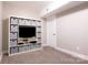 Cozy carpeted basement room with custom shelving unit and ample space for entertaining at 8340 Brief Rd, Mint Hill, NC 28227