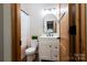Bathroom featuring white vanity, decorative mirror, wood accents, and a toilet at 8340 Brief Rd, Mint Hill, NC 28227
