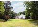Charming white home with inviting front porch nestled on a serene lot with lush greenery at 8340 Brief Rd, Mint Hill, NC 28227
