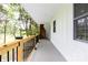 Covered porch features wood railing with the views of tree lined lawn at 8340 Brief Rd, Mint Hill, NC 28227