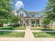 Charming two-story home with a inviting porch and well-maintained lawn and mature trees at 9405 Gladden Hill Ln, Pineville, NC 28134