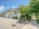 Charming home exterior featuring a grill, seating area, and a well-manicured lawn with mature trees at 9405 Gladden Hill Ln, Pineville, NC 28134