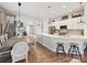 Open-concept kitchen and dining area with white cabinets, a quartz countertop island, and hardwood flooring at 9405 Gladden Hill Ln, Pineville, NC 28134
