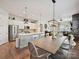 Open concept kitchen with white cabinets and a large dining table and chairs at 9405 Gladden Hill Ln, Pineville, NC 28134