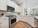 Close up view of a modern kitchen with stainless steel appliances and tiled backsplash at 9405 Gladden Hill Ln, Pineville, NC 28134