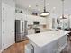 Bright modern kitchen with white cabinetry, stainless steel appliances, and a spacious island with counter seating at 9405 Gladden Hill Ln, Pineville, NC 28134