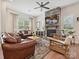 Spacious living room featuring a stone fireplace, ceiling fan, and lots of natural light at 9405 Gladden Hill Ln, Pineville, NC 28134