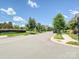 Wide shot of a quiet residential street showcasing the community's landscaping and single Gathering homes under a blue sky at 9405 Gladden Hill Ln, Pineville, NC 28134