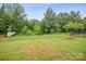 A beautifully landscaped backyard with vibrant green grass and mature trees at 9525 Festival Way, Charlotte, NC 28215