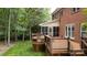 Spacious outdoor deck with wooden railing and view of the screened porch and a lush, green lawn at 9901 Pallisers Ter, Charlotte, NC 28210