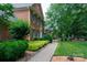 Charming brick home with lush landscaping and a brick walkway through the yard at 9901 Pallisers Ter, Charlotte, NC 28210