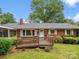 Charming brick home with well-maintained lawn, front yard landscaping, and wooden ramp to the front door at 1008 Midway Dr, Gastonia, NC 28054