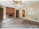 Warm living room featuring a brick fireplace, built-in shelves, and cozy carpeting at 1008 Midway Dr, Gastonia, NC 28054
