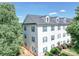 Three-story condo features white siding, dark blue shutters and mature trees surrounding the building at 1023 Triece Ln, Charlotte, NC 28215