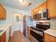 Updated kitchen with stainless appliances, wood cabinets and a view to the utility closet at 1023 Triece Ln, Charlotte, NC 28215