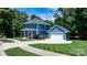 Stunning blue two-story house with a detached garage, manicured lawn, and welcoming front porch at 1067 33Rd Avenue Ne Loop, Hickory, NC 28601
