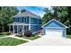 Beautiful blue two-story home featuring a covered porch, well-manicured lawn, and a detached garage at 1067 33Rd Avenue Ne Loop, Hickory, NC 28601