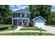 Charming two-story blue home with a detached garage, lush landscaping and well-manicured lawn at 1067 33Rd Avenue Ne Loop, Hickory, NC 28601