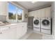 Well-lit laundry room with a large window, modern washer and dryer units, and ample storage at 123 Sailview Rd, Mooresville, NC 28117