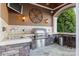 A well-equipped outdoor kitchen area features a stainless steel grill, sink, stone accents, and comfortable bar seating at 123 Sailview Rd, Mooresville, NC 28117
