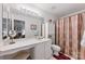 Well-lit bathroom featuring a vanity area, toilet, and shower-tub with a decorative curtain at 12350 Swan Wings Pl, Huntersville, NC 28078
