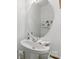 Bathroom featuring a white pedestal sink, oval mirror, and floral-themed decor at 12350 Swan Wings Pl, Huntersville, NC 28078