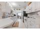 Galley kitchen featuring white cabinets, countertops, appliances, with stainless steel refrigerator, and easy access to living area at 12350 Swan Wings Pl, Huntersville, NC 28078