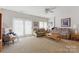 Spacious living room with comfortable seating, neutral carpet, and natural light from the door and windows at 12350 Swan Wings Pl, Huntersville, NC 28078