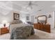 Bright main bedroom with white walls, tray ceiling, ceiling fan, and wood furniture at 12350 Swan Wings Pl, Huntersville, NC 28078