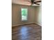 An interior view showcases a bedroom with wood-look floors and a bright window overlooking a green, outdoor space at 136 Ridge Run Dr, Statesville, NC 28625