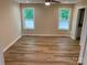 Bright bedroom with two windows, ceiling fan, and wood-look flooring at 136 Ridge Run Dr, Statesville, NC 28625