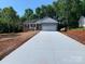 Charming one-story home featuring a two-car garage, green siding, and a long concrete driveway at 136 Ridge Run Dr, Statesville, NC 28625