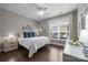 Cozy bedroom with wood floors, a ceiling fan, and a large window offering natural light at 17112 Courtside Landing Dr, Cornelius, NC 28031