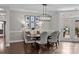 Lovely dining room with a wooden dining table, gray upholstered chairs, and an elegant chandelier at 17112 Courtside Landing Dr, Cornelius, NC 28031