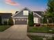Charming home featuring stone accents, gray siding, well-manicured landscaping, and a two-car garage at 17112 Courtside Landing Dr, Cornelius, NC 28031