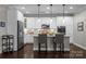 Modern kitchen with white cabinets, stainless steel appliances, granite countertops, and bar seating at 17112 Courtside Landing Dr, Cornelius, NC 28031