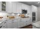 Bright kitchen with white cabinetry, stainless steel microwave, granite countertops and stainless gas cooktop at 17112 Courtside Landing Dr, Cornelius, NC 28031