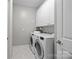 Bright laundry room with white cabinets and modern washer and dryer for efficient convenience at 17112 Courtside Landing Dr, Cornelius, NC 28031