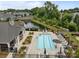 Aerial view of a community pool with lounge chairs, tables, umbrellas, and lovely landscaping at 17112 Courtside Landing Dr, Cornelius, NC 28031