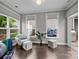 Bright sunroom featuring large windows, cozy seating area, and access to the outdoor space at 17112 Courtside Landing Dr, Cornelius, NC 28031