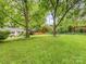 Lush backyard features mature trees and green grass, creating a private outdoor setting at 1723 Woodland Dr, Charlotte, NC 28205